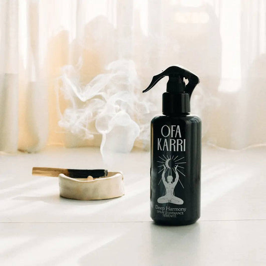 Schwarze Ofa Karri Raumspray-Flasche für Entspannung, daneben Räucherschale mit aufsteigendem Rauch, helle ruhige Atmosphäre.