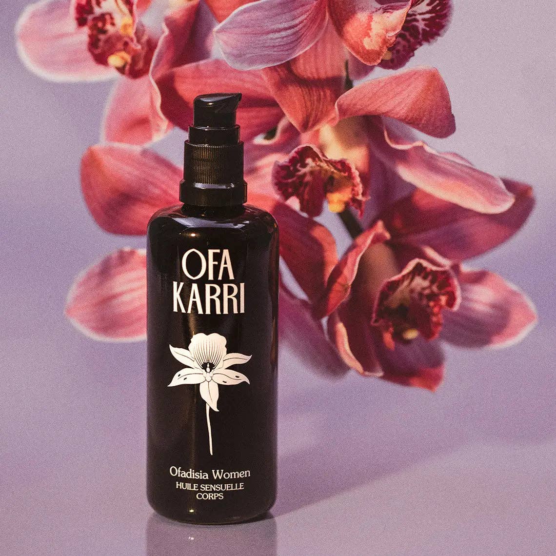 Schwarze Flasche Körperöl mit Blumenmotiv, vor rosa Orchideen auf lila Hintergrund