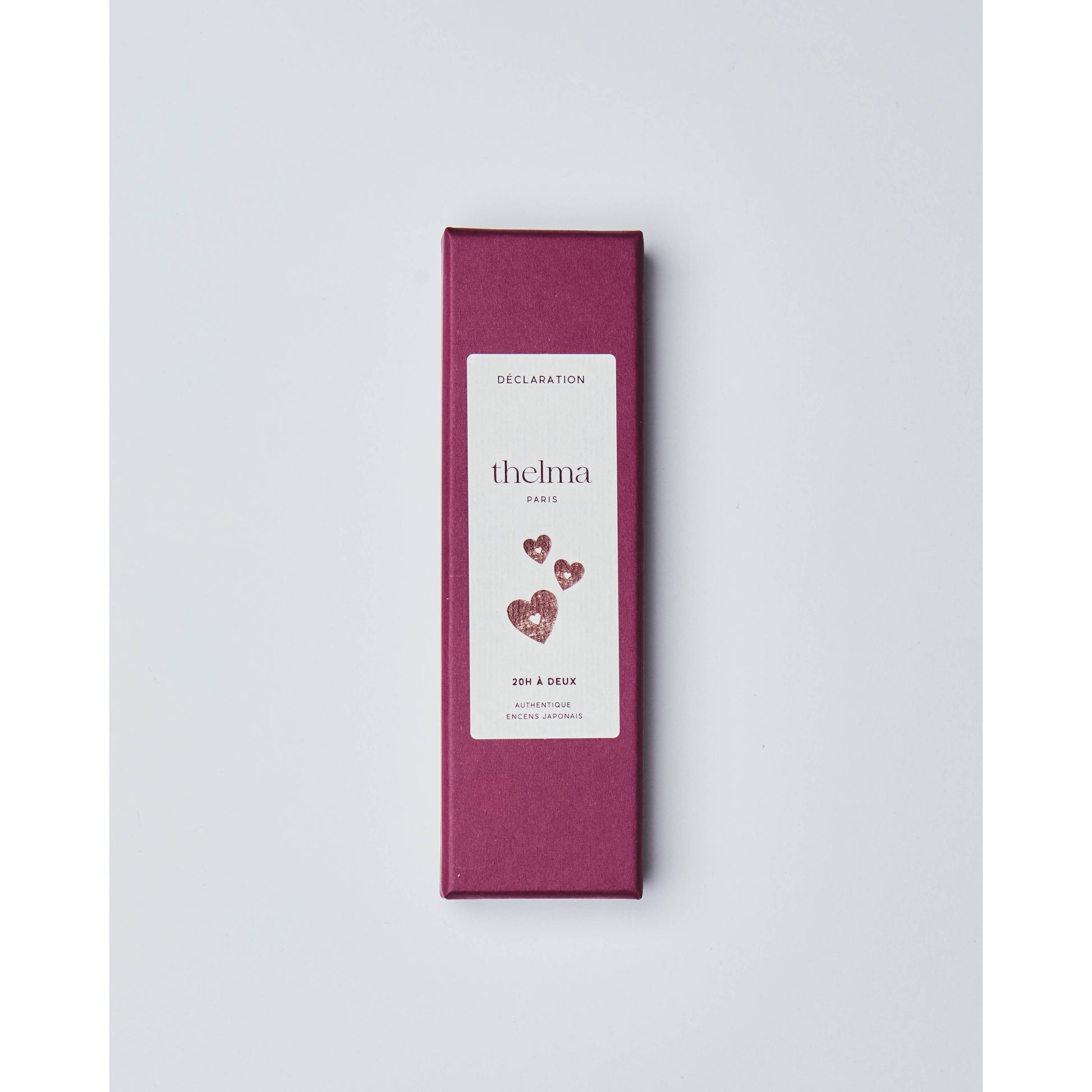 Rote Geschenkbox mit weißem Etikett, Herzen und Schriftzug, auf weißem Hintergrund