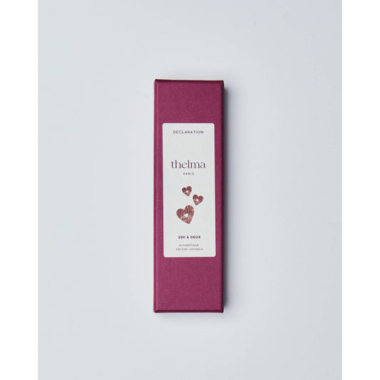 Rote Geschenkbox mit weißem Etikett, Herzen und Schriftzug, auf weißem Hintergrund
