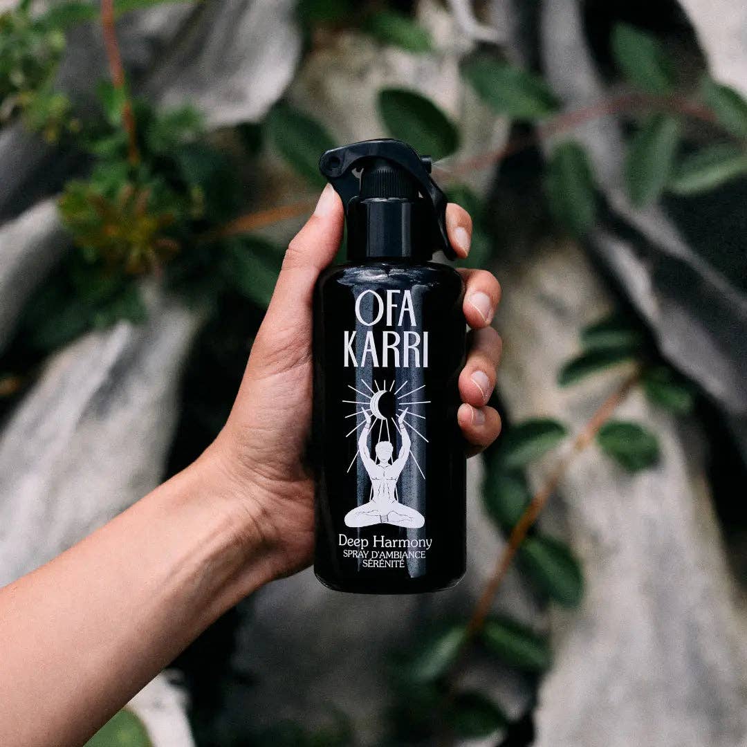 Hand hält OFA KARRI Deep Harmony Raumduft Spray vor natürlichem Hintergrund