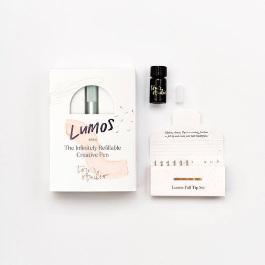 Lumos Mini Set mit nachfüllbarem Kreativ-Stift, Tintenfläschchen und Ersatzspitzen auf weißem Hintergrund.