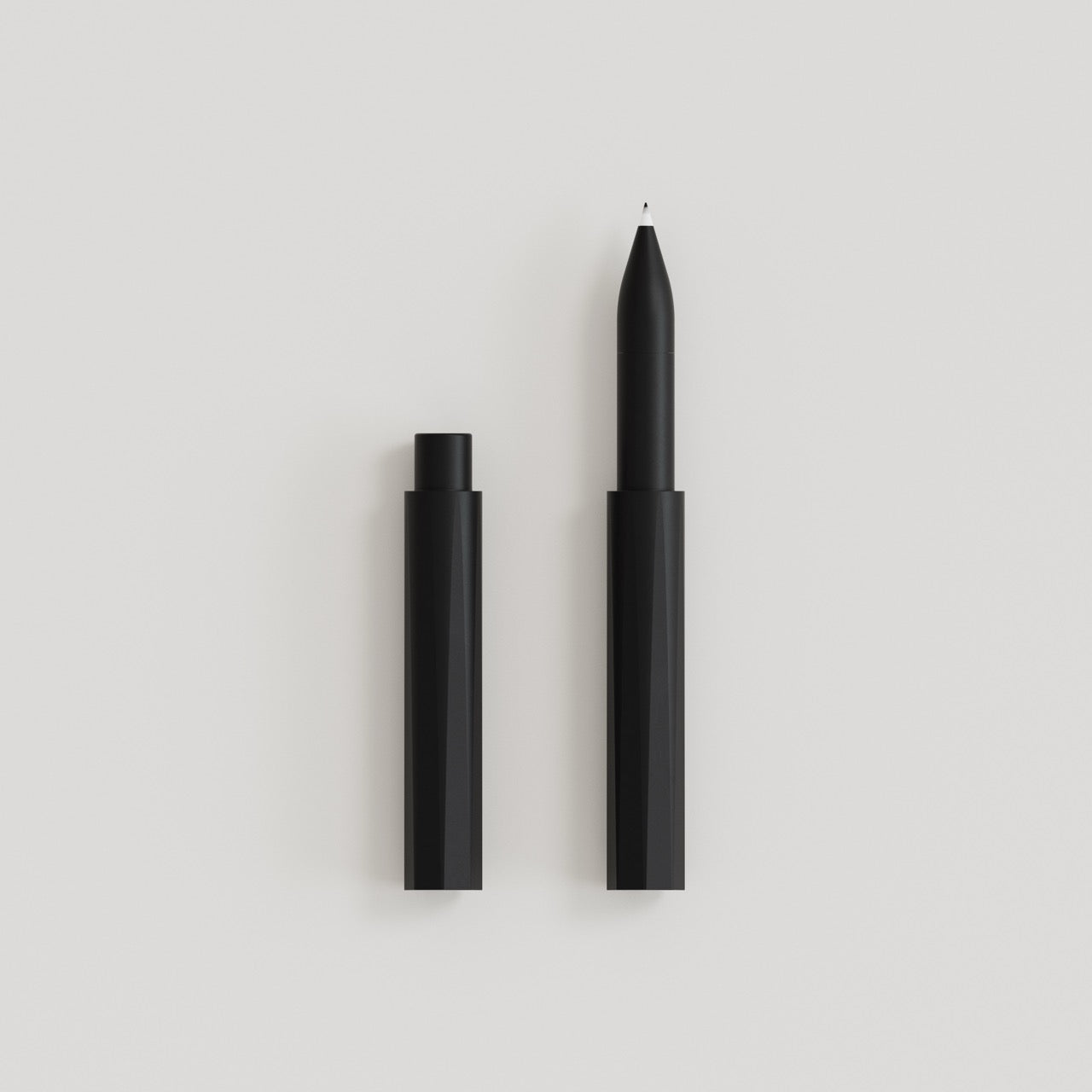 Schwarzer, minimalistischer Stift mit abgenommener Kappe auf weißem Hintergrund