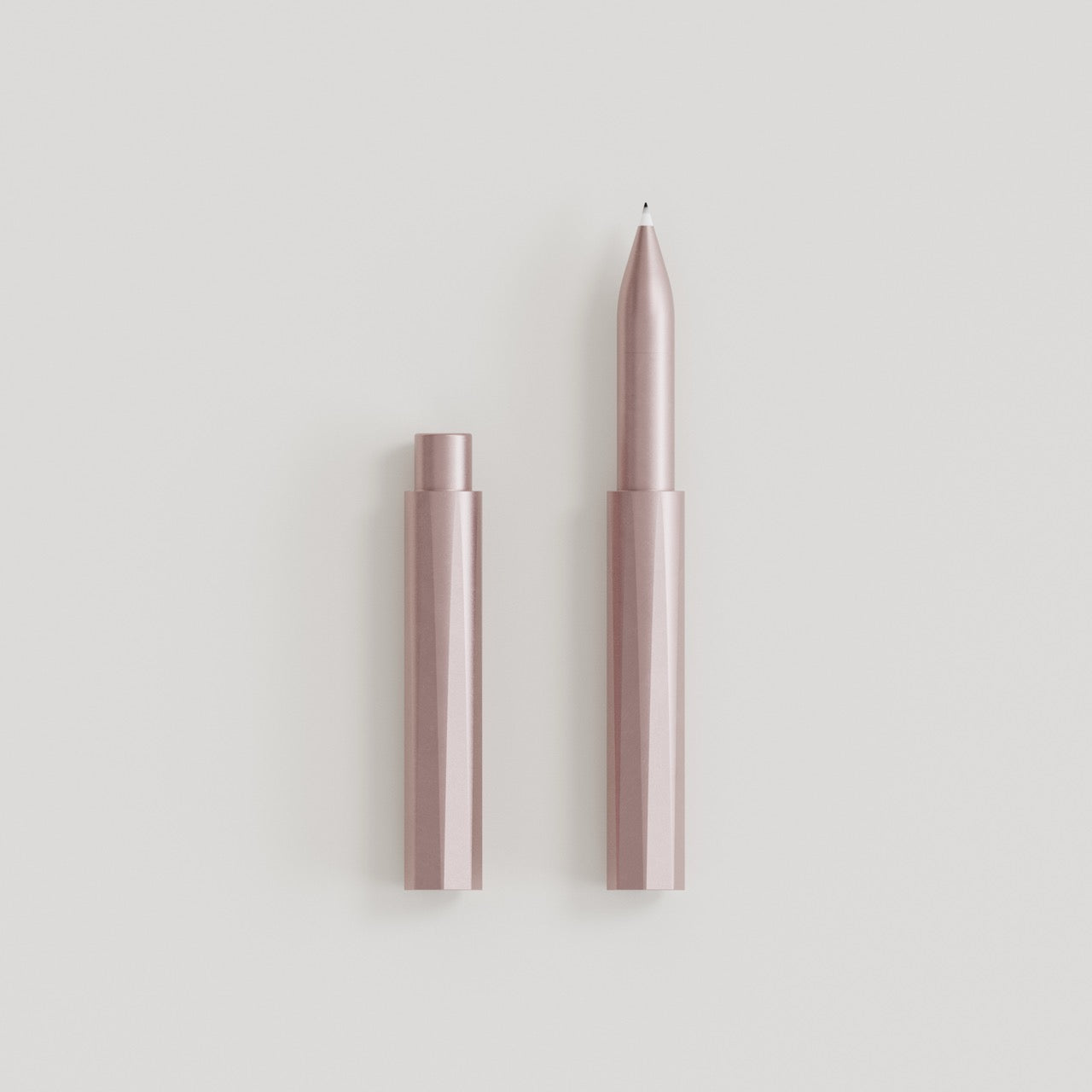 Minimalistischer Kugelschreiber in Roségold mit abgenommener Kappe auf weißem Hintergrund