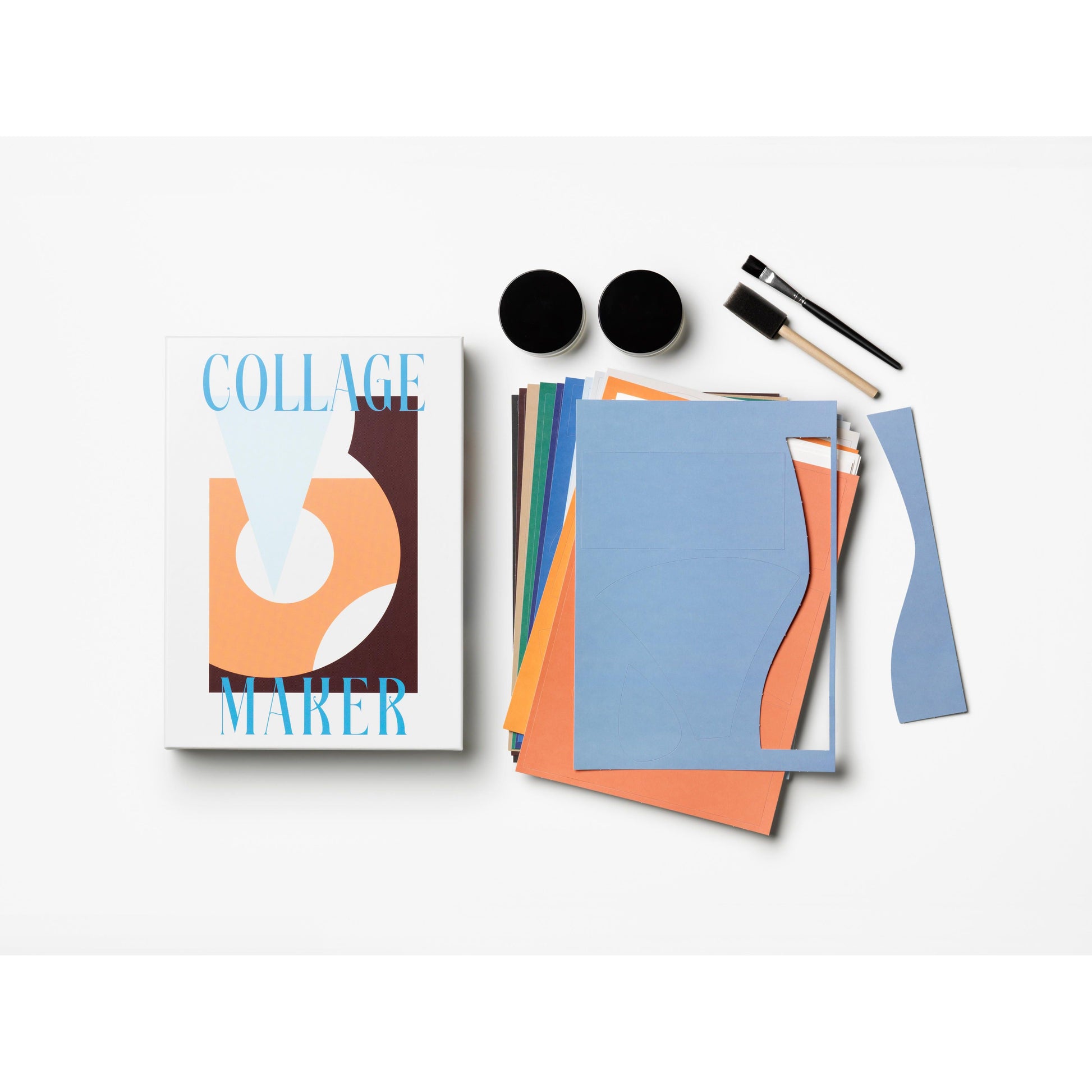 Collage Maker Set mit bunten Papierbögen, Pinseln, Kleber und Verpackung auf weißem Hintergrund.