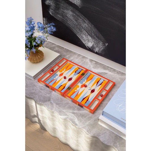 Modernes, buntes Backgammon-Spiel auf Marmortisch, daneben Blumen und Bücher, wohnliches Setting