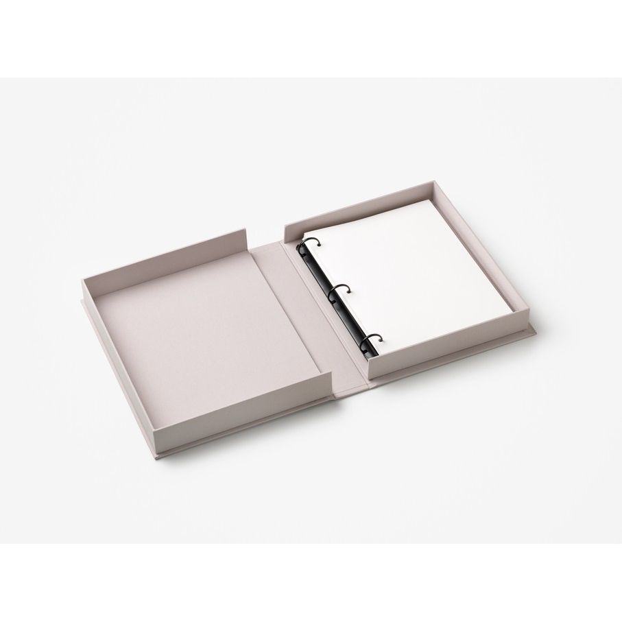 Offenes, elegantes Ringbuch mit leerem Papier in minimalistischer Box auf weißem Hintergrund