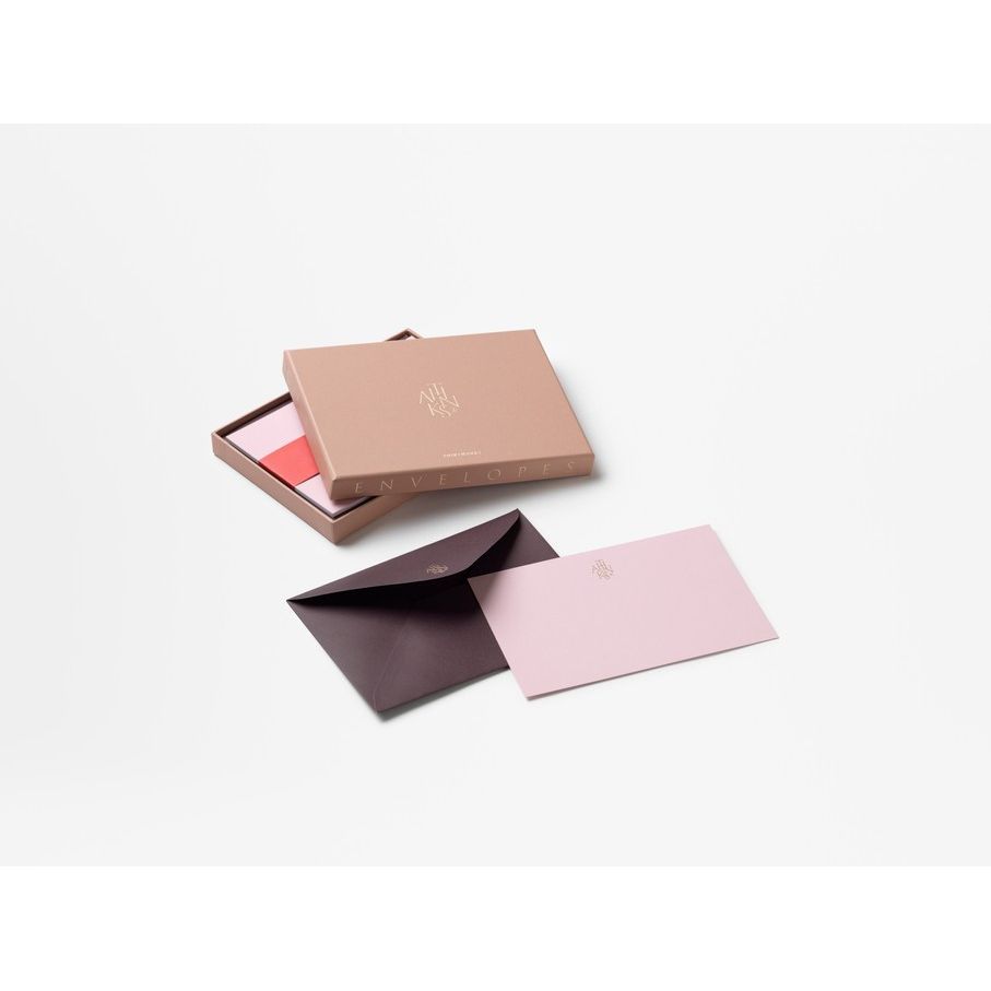 Edle Umschläge in Geschenkbox, rosa und dunkelviolett, auf weißem Hintergrund.