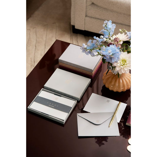 Elegantes Briefpapier-Set mit Umschlägen, Karten und Kugelschreiber auf Tisch, Blumen in Vase