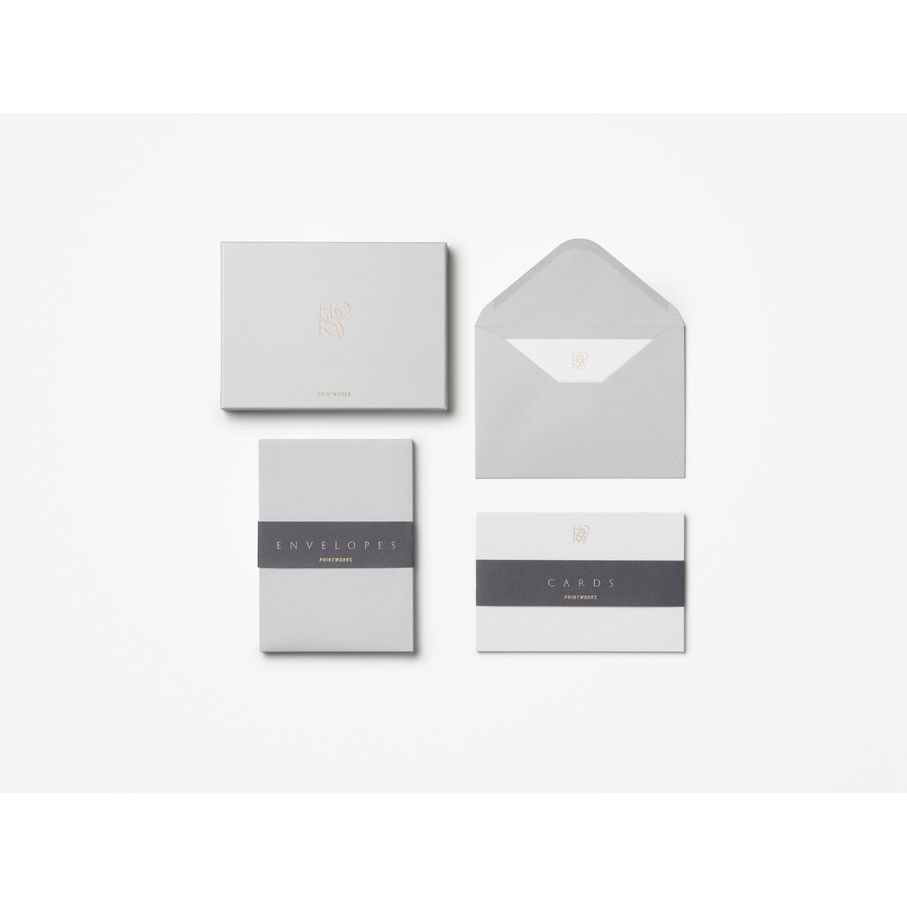 Elegantes Set aus grauen Briefumschlägen und Karten auf weißem Hintergrund, minimalistisches Design