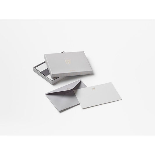 Elegantes Schreibset mit grauer Box, Briefpapier und Umschlag auf weißem Hintergrund