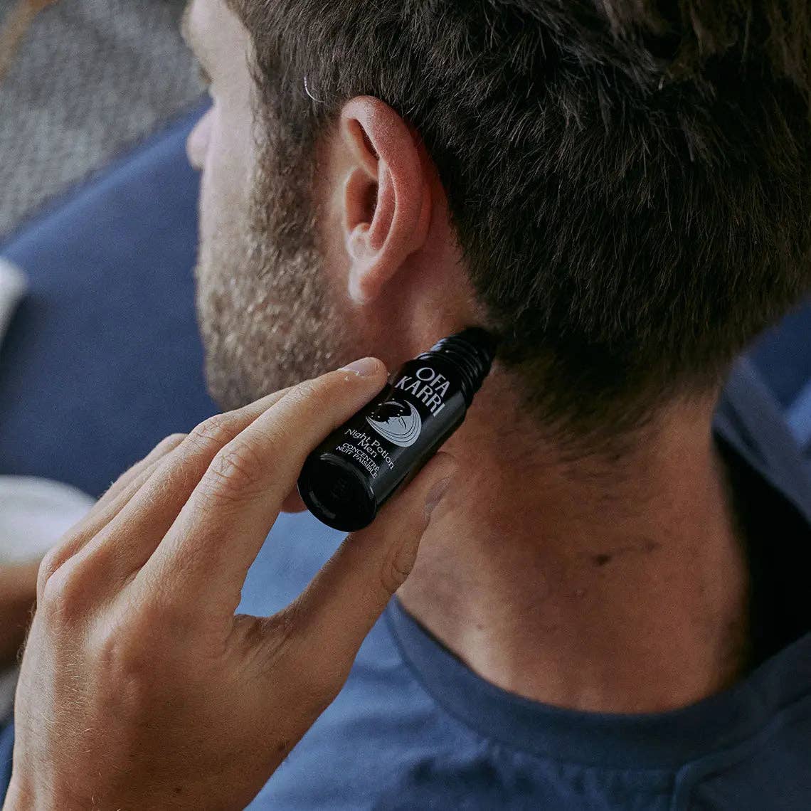 Mann trägt Roll-On Aromaöl auf Nacken für Entspannung und Wohlbefinden auf