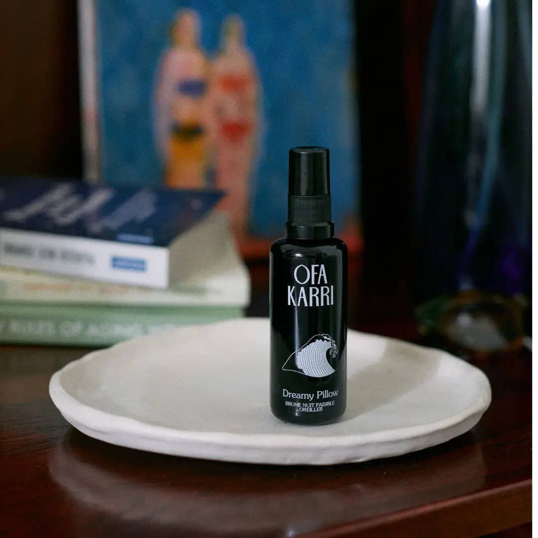 Schwarze Ofa Karri Dreamy Pillow Sprühflasche auf weißer Keramikschale, Bücher im Hintergrund