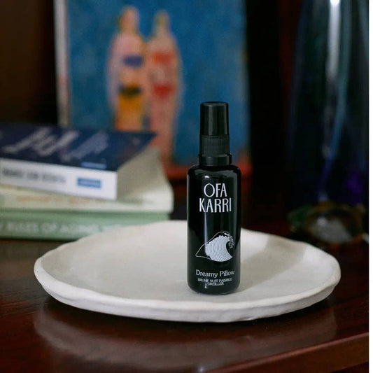 Schwarze Ofa Karri Dreamy Pillow Sprühflasche auf weißer Keramikschale, Bücher im Hintergrund