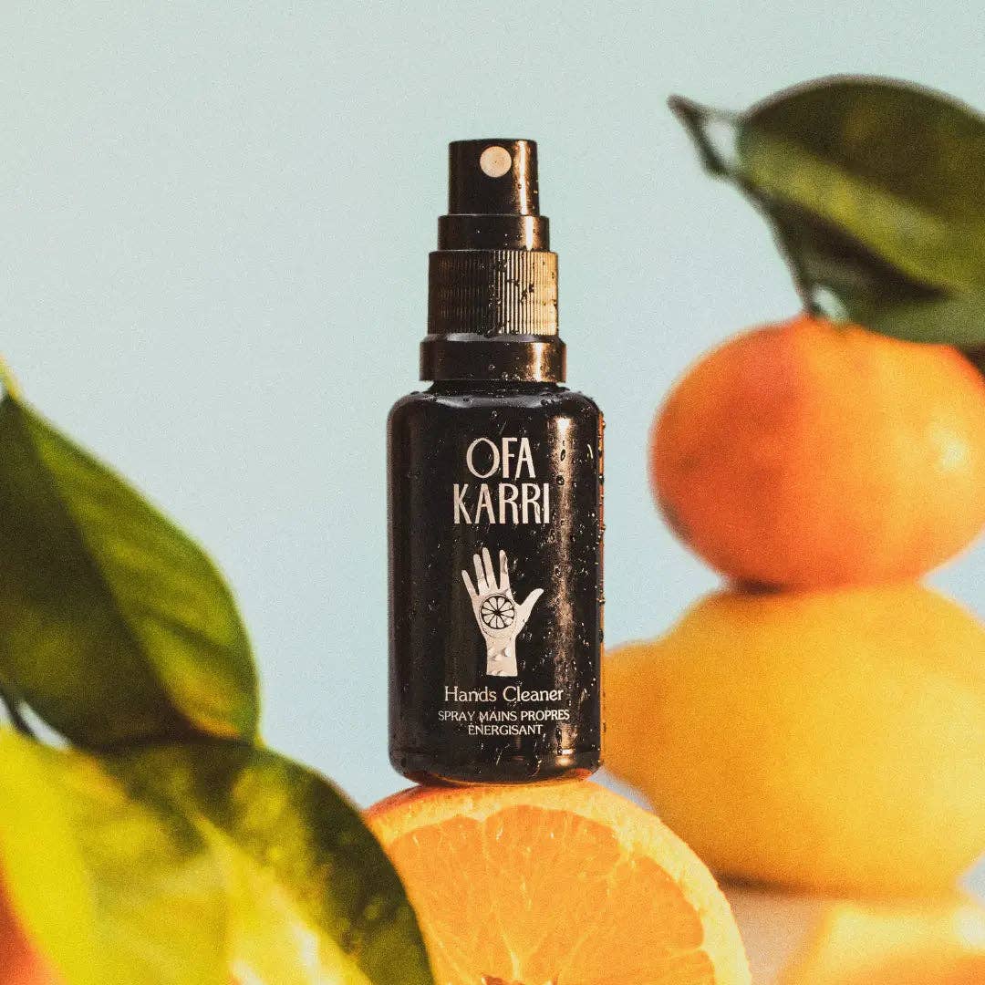 Schwarze Handreinigungsspray-Flasche mit Zitrusfrüchten und grünen Blättern dekoriert