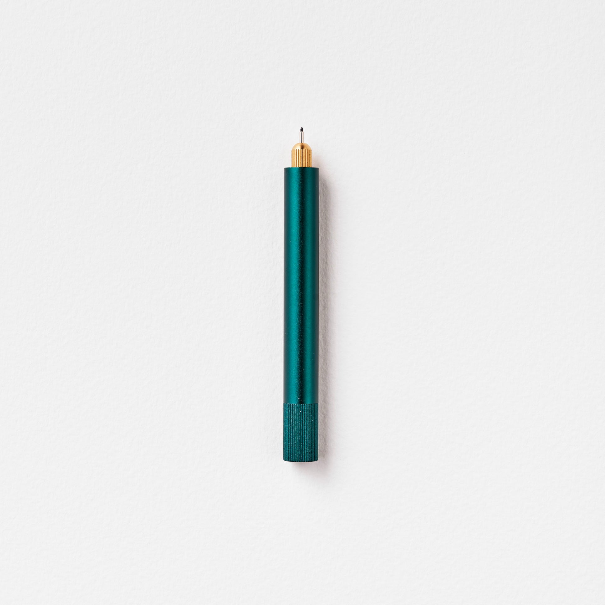 Minimalistischer Kugelschreiber in grün und gold auf weißem Hintergrund, Design Schreibtisch-Accessoire