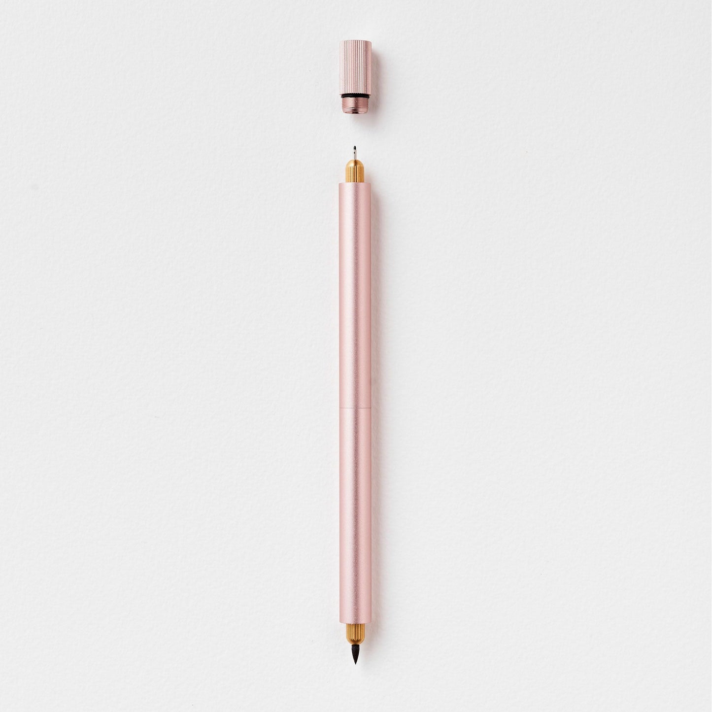 Eleganter rosafarbener Stift mit abgenommener Kappe auf weißem Hintergrund