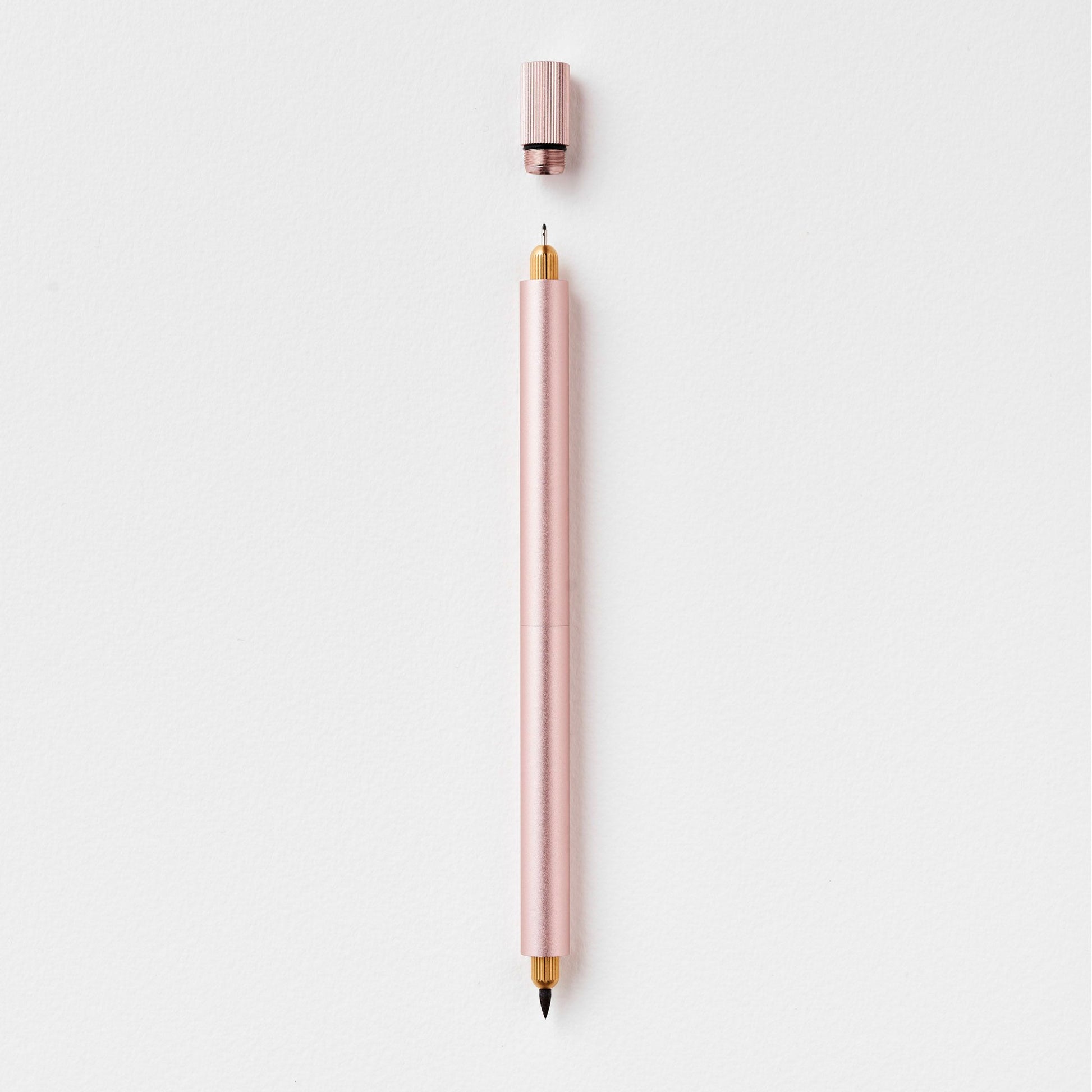 Eleganter rosafarbener Stift mit abgenommener Kappe auf weißem Hintergrund