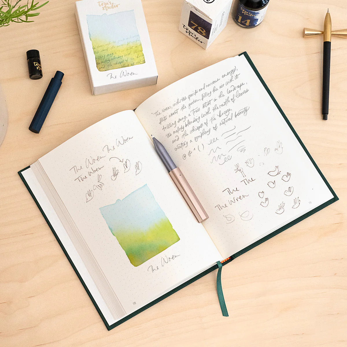 Offenes Notizbuch mit handschriftlichen Notizen, Füllfederhalter, Tinte und Tintekarton auf hellem Holztisch