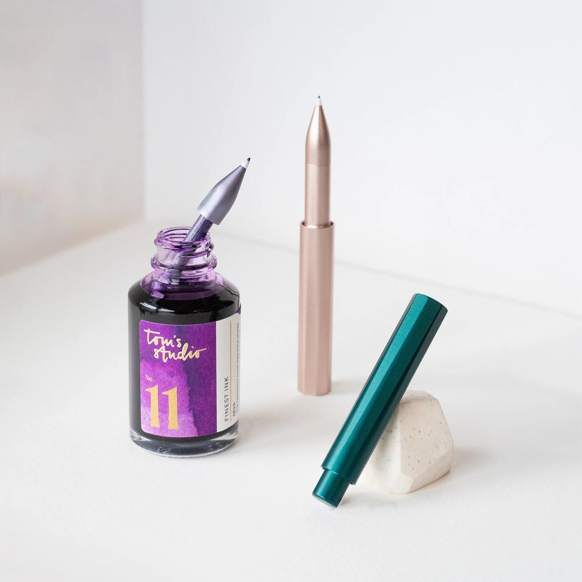 Design-Füller mit grünem Gehäuse, Tinte und Stiftkappe auf weißem Hintergrund
