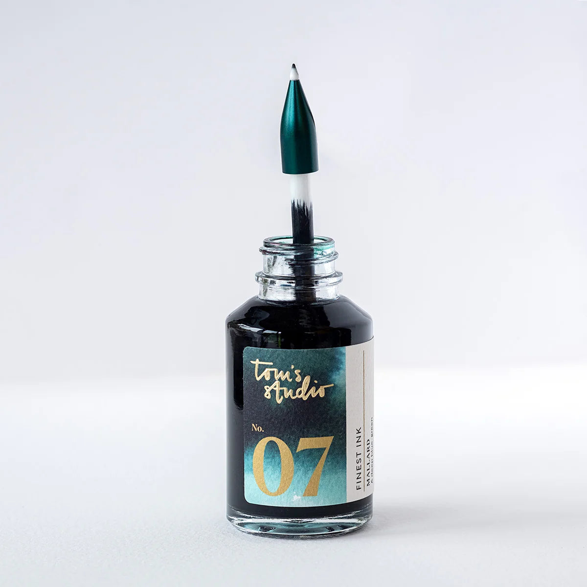 Schwarze Tinte in Glasflasche mit Pinsel, modernes Schreibwaren-Design auf weißem Hintergrund